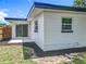Exterior back view showcasing white block construction, sliding door, and wood fence at 3321 Mahalia Pl, Orlando, FL 32805