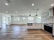 Open kitchen with center island, stainless steel appliances, decorative tile backsplash and wood flooring throughout at 3321 Mahalia Pl, Orlando, FL 32805