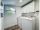 A functional laundry room with a washer, dryer, and ample cabinet space at 3321 Mahalia Pl, Orlando, FL 32805