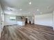 Open-concept living area with wood floors, modern lighting, and a view of the stylish kitchen at 3321 Mahalia Pl, Orlando, FL 32805