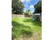 A large, grassy fenced backyard has a playground slide and mature trees at 34 W Bob White St, Apopka, FL 32712