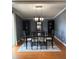 Charming dining room with a glass table set for six, complemented by grey walls at 34 W Bob White St, Apopka, FL 32712