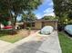 Lovely home with mature landscaping and a covered vehicle in the driveway at 34 W Bob White St, Apopka, FL 32712