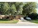 Cozy home with a large, mature tree in the front yard and a covered vehicle in the driveway at 34 W Bob White St, Apopka, FL 32712