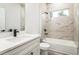 Modern bathroom with marble tile, white vanity and cabinets, tub, and black hardware at 3832 Sw 157Th Place Rd, Ocala, FL 34473