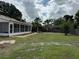 Expansive backyard with mature trees, a screened-in porch and privacy fence offering an outdoor oasis at 3917 Lake Mira Dr, Orlando, FL 32817