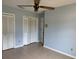 A light-blue bedroom features tiled floor, white closet doors, a ceiling fan and view of the door at 3917 Lake Mira Dr, Orlando, FL 32817