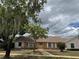 Charming single-story brick home featuring a well-maintained lawn, mature trees and inviting facade at 3917 Lake Mira Dr, Orlando, FL 32817