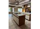 Open-concept kitchen featuring a center island, cooktop, white countertops, wood cabinets and tiled floors at 3917 Lake Mira Dr, Orlando, FL 32817