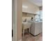 Well-lit laundry room featuring washer, dryer, laundry sink and tiled floor with shelves for storage at 3917 Lake Mira Dr, Orlando, FL 32817