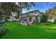 A lush green backyard with patio furniture sits behind this two-story home at 394 Baymoor Way, Lake Mary, FL 32746