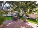 Outdoor patio area with a grill, a dining table with an umbrella, and a well-manicured lawn at 394 Baymoor Way, Lake Mary, FL 32746