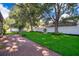 Expansive backyard featuring a brick paver patio, lush lawn, mature trees, and a privacy fence at 394 Baymoor Way, Lake Mary, FL 32746