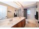 Well-lit bathroom with a double sink vanity and a shower-tub combination with black and white accents at 394 Baymoor Way, Lake Mary, FL 32746