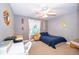 Comfortable bedroom with a bed, a desk, a ceiling fan, and natural light from the windows at 394 Baymoor Way, Lake Mary, FL 32746