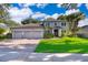 Beautiful gray home with a three-car garage, lush landscaping, and a vibrant green lawn at 394 Baymoor Way, Lake Mary, FL 32746