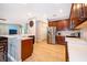 Open kitchen featuring stainless steel appliances, wooden cabinets, quartz countertops, and wood-look tile flooring at 394 Baymoor Way, Lake Mary, FL 32746