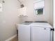 Bright laundry room with modern washer and dryer, overhead cabinet and small sink at 394 Baymoor Way, Lake Mary, FL 32746