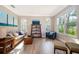 Bright living room with wood-look tile floors, comfortable seating, and large windows at 394 Baymoor Way, Lake Mary, FL 32746
