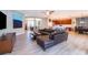 Open living room featuring wood-look tile floors, a large leather couch, and seamless transition to the kitchen at 394 Baymoor Way, Lake Mary, FL 32746