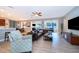 Spacious living room with wood-look tile floors, ceiling fan, and views to the outside through sliding glass doors at 394 Baymoor Way, Lake Mary, FL 32746