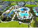 Aerial view of the community's water park which includes a large pool, waterslides, playground, and surrounding greenery at 421 Southfield St, Kissimmee, FL 34747