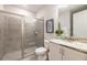 Bathroom featuring a glass-enclosed shower with tile surround, white vanity, and granite countertop at 421 Southfield St, Kissimmee, FL 34747
