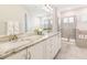 Bathroom featuring double sinks with granite countertops, white cabinetry, and a glass-enclosed shower at 421 Southfield St, Kissimmee, FL 34747