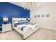 Bedroom with a king bed, white furniture, and a blue accent wall, creating a serene and coastal atmosphere at 421 Southfield St, Kissimmee, FL 34747