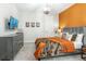 Bedroom with orange accent wall, soft carpet, and ample natural light at 421 Southfield St, Kissimmee, FL 34747