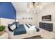 Nautical themed bedroom with king bed, rope chandelier, blue accent wall and TV on dresser at 421 Southfield St, Kissimmee, FL 34747
