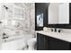 Well-lit bathroom featuring a tub with marble surround, stylish vanity, and modern fixtures at 4310 Ethan Lane Ln, Orlando, FL 32814