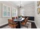 Stylish dining room featuring modern light fixture, decorative wallpaper, and seating for six at 4310 Ethan Lane Ln, Orlando, FL 32814