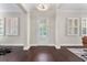 Elegant foyer showcasing dark wood floors, white trim, plantation shutters, and a modern chandelier at 4310 Ethan Lane Ln, Orlando, FL 32814
