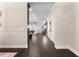 Long hallway featuring dark wood floors, white trim, leading into the living room and kitchen at 4310 Ethan Lane Ln, Orlando, FL 32814