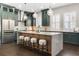 Gourmet kitchen featuring a large marble island, stainless steel appliances, and custom green cabinets at 4310 Ethan Lane Ln, Orlando, FL 32814