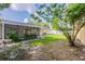 Grassy backyard featuring a screened in patio, perfect for outdoor living and entertaining at 4800 Reginald Rd, Orlando, FL 32829