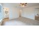 Bright primary bedroom featuring neutral carpet, a ceiling fan, an ensuite and a large closet at 4800 Reginald Rd, Orlando, FL 32829