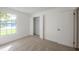 Bedroom boasting natural light, neutral carpet, closet, and a large window overlooking the neighborhood at 4800 Reginald Rd, Orlando, FL 32829