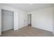 Bedroom featuring neutral carpet, an open closet, and a view into the hall with carpeted floors at 4800 Reginald Rd, Orlando, FL 32829