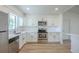 Well-lit kitchen showcases stainless steel appliances, white cabinets, and light countertops and flooring at 4800 Reginald Rd, Orlando, FL 32829