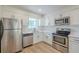 Bright kitchen featuring stainless steel appliances, white cabinets, and light countertops at 4800 Reginald Rd, Orlando, FL 32829