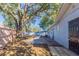 Spacious backyard featuring mature trees, a wood fence, and a concrete patio at 4933 Balboa Dr, Orlando, FL 32808