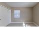 An empty bedroom with white floors, a window, and a closet offers versatility at 4933 Balboa Dr, Orlando, FL 32808