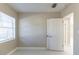 Neutral room showcasing tile flooring, a window with blinds, and a white door at 4933 Balboa Dr, Orlando, FL 32808