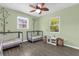 Bright bedroom featuring two cribs, hardwood floors, and tree-themed decorations at 4959 Ardmore Dr, Winter Park, FL 32792