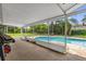 A screened-in porch overlooks a sparkling pool surrounded by lush landscaping at 4959 Ardmore Dr, Winter Park, FL 32792