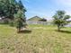 Level backyard with plenty of green space, a white fence and young trees, ideal for outdoor activities at 584 S Andrea Cir, Haines City, FL 33844