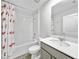 The bathroom has a shower and tub combo, toilet, white countertop and grey cabinets at 584 S Andrea Cir, Haines City, FL 33844