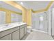 Well-lit bathroom featuring a double sink vanity and a glass enclosed shower, combining style and functionality at 584 S Andrea Cir, Haines City, FL 33844